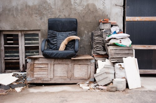 Team member organizing a cluttered room during hoarder clearance in Loxford